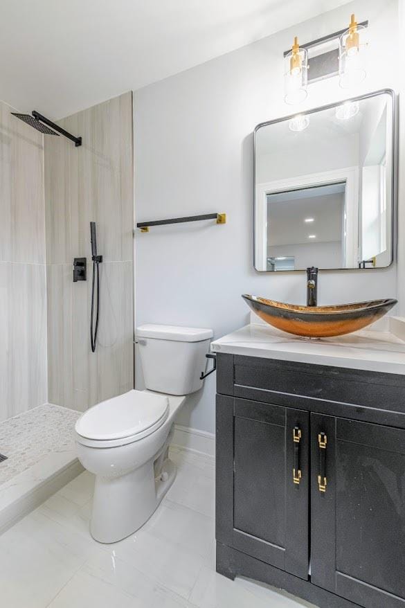 612 Thornwood Dr, South Holland, IL 60473 - bathroom with vanity, baseboards, a tile shower, and toilet
