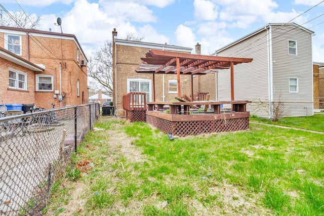back of house with a wooden deck, a pergola, fence, brick siding, and a yard