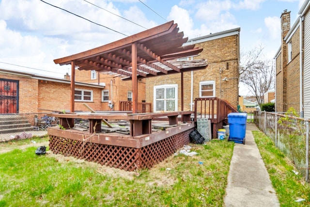 back of property with brick siding, a pergola, fence, and a deck