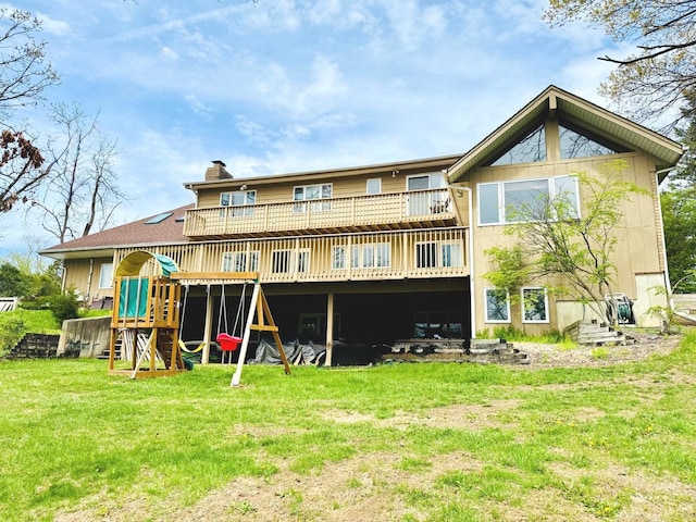 back of house with a playground, a chimney, a yard, and a deck