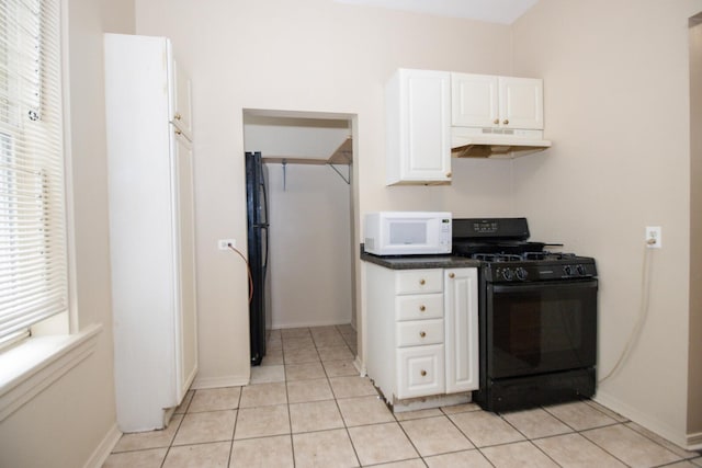 kitchen with white cabinets, black range with gas stovetop, light tile patterned floors, white microwave, and under cabinet range hood