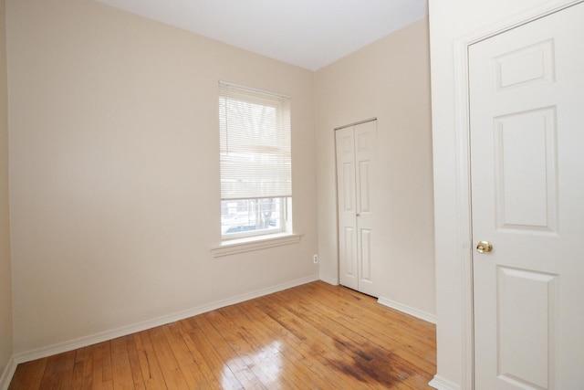 empty room featuring baseboards and light wood-type flooring