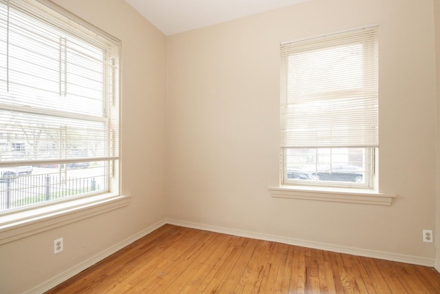 unfurnished room with baseboards and light wood-type flooring