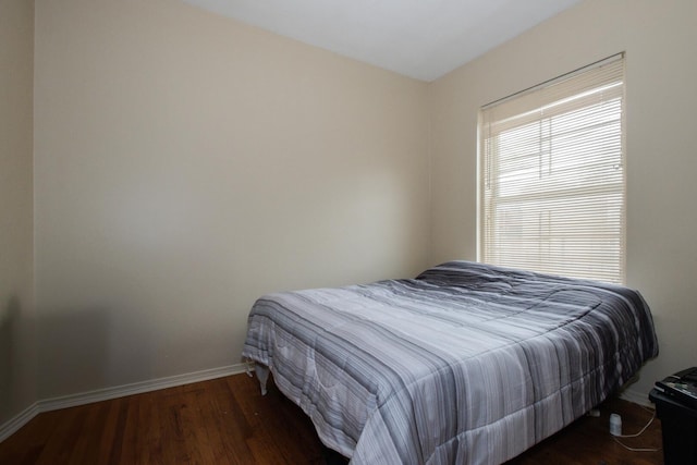 bedroom with baseboards and wood finished floors