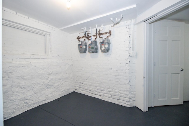 unfurnished dining area featuring concrete floors and brick wall