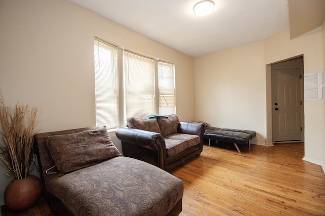 living area featuring baseboards and light wood-style flooring