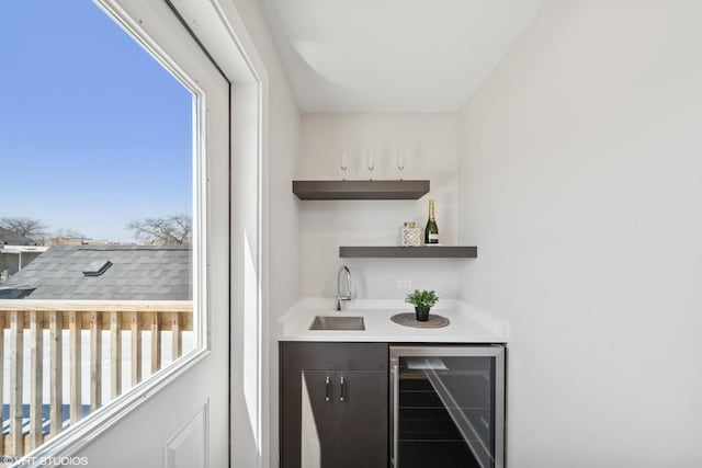 bar with a sink, indoor wet bar, and beverage cooler