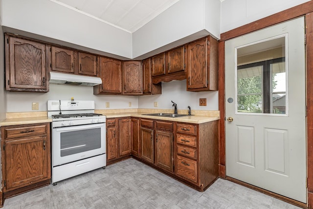 115 Van Buren St, Savanna, IL 61074 - kitchen featuring white gas range oven, under cabinet range hood, a sink, light countertops, and light floors