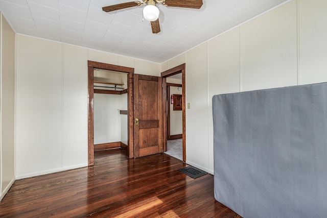 115 Van Buren St, Savanna, IL 61074 - unfurnished bedroom with dark wood-type flooring, baseboards, and a ceiling fan