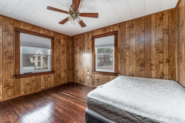 115 Van Buren St, Savanna, IL 61074 - bedroom featuring wood-type flooring, baseboards, wooden walls, and a ceiling fan