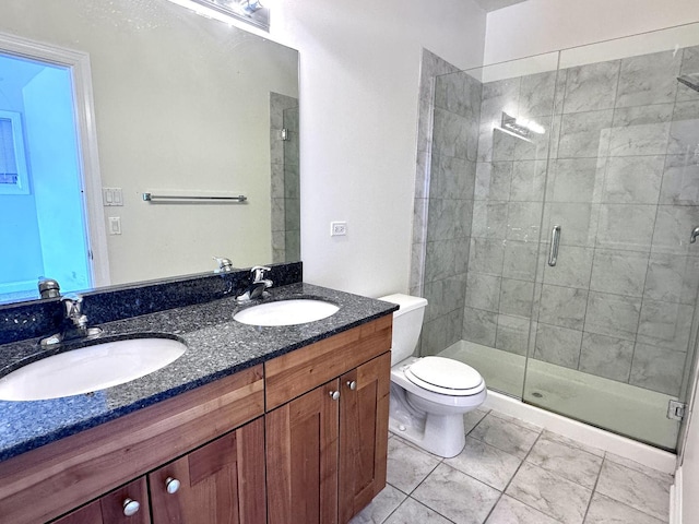full bath featuring a sink, a stall shower, toilet, and double vanity