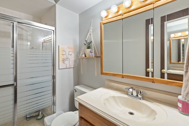 bathroom with a stall shower, vanity, and toilet