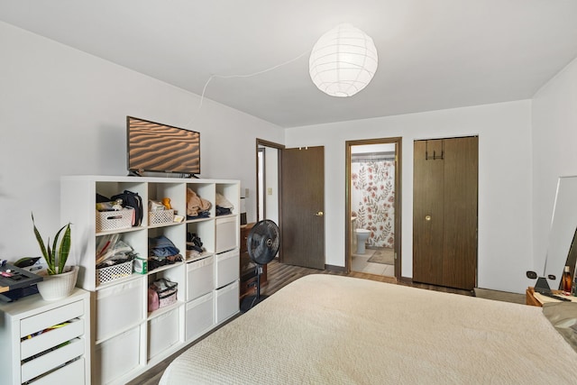 bedroom featuring connected bathroom and wood finished floors