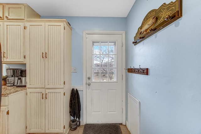 doorway to outside with light tile patterned flooring