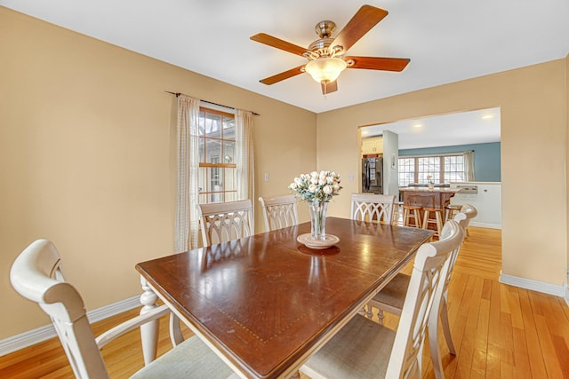 dining area with baseboards, light wood finished floors, and ceiling fan