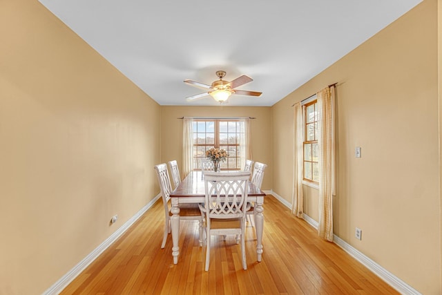 dining area with baseboards, light wood-style flooring, and ceiling fan