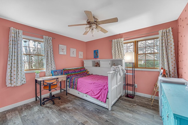 bedroom featuring baseboards, multiple windows, and wood finished floors