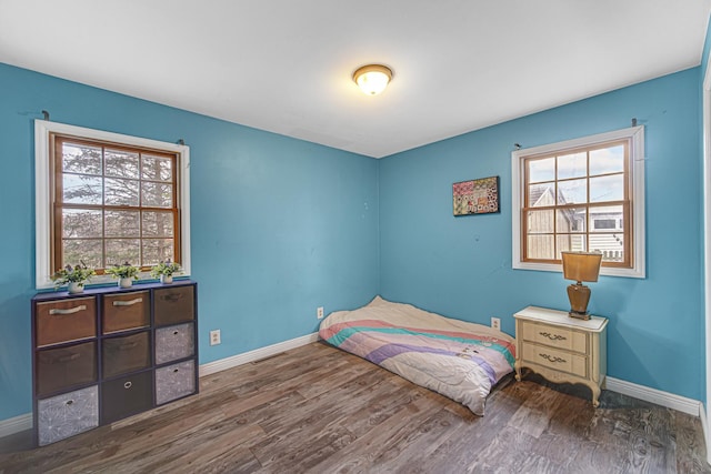 bedroom with baseboards and wood finished floors