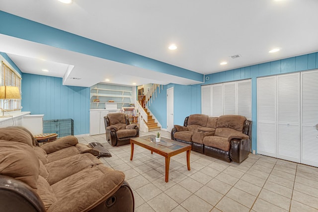 living room featuring light tile patterned flooring, built in shelves, stairs, recessed lighting, and visible vents