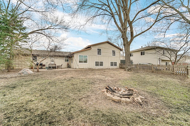 back of house with a patio, a fenced backyard, board and batten siding, and a fire pit