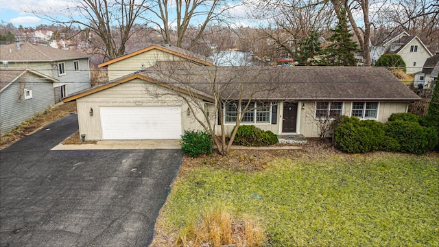 view of front of property with a garage, a shingled roof, a front lawn, and aphalt driveway