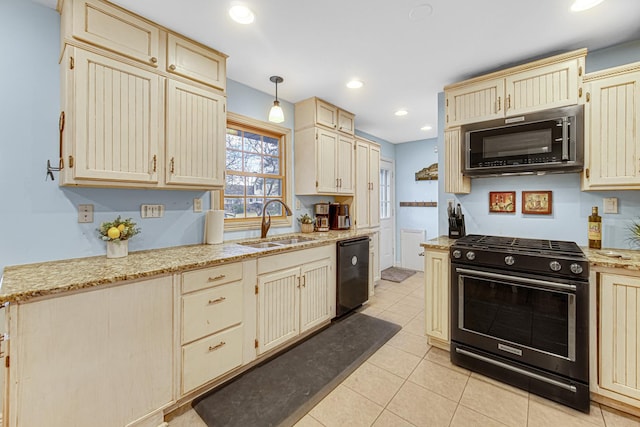 kitchen with a sink, light tile patterned floors, black appliances, and cream cabinets