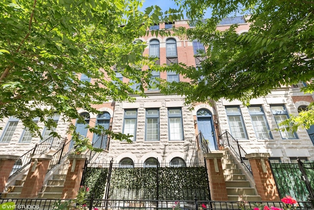 view of property featuring a fenced front yard and stairs