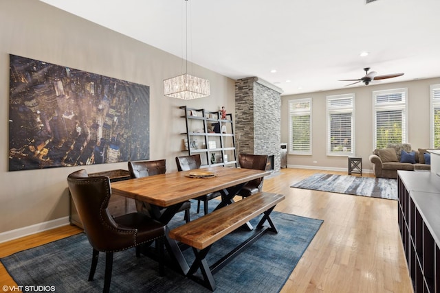 dining room with baseboards, ceiling fan with notable chandelier, recessed lighting, and wood finished floors