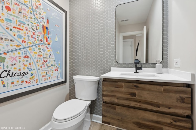 bathroom featuring visible vents, toilet, and vanity