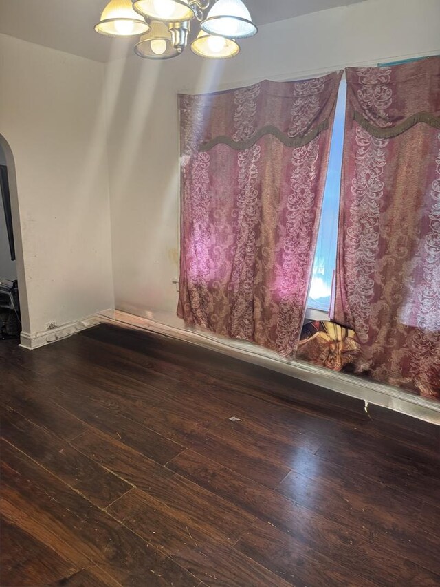 7328 S May St, Chicago, IL 60621 - unfurnished room with an inviting chandelier, arched walkways, and hardwood / wood-style floors