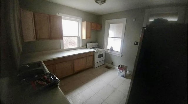 7328 S May St, Chicago, IL 60621 - kitchen featuring baseboards, gas range gas stove, light tile patterned flooring, and light countertops