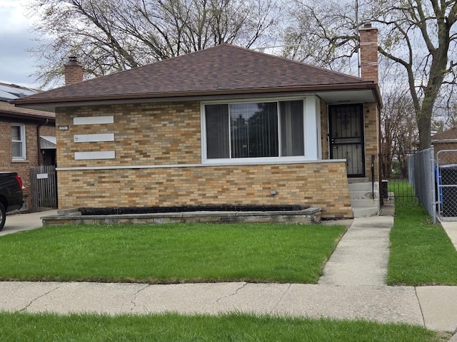 bungalow-style house featuring brick siding, fence, a chimney, and roof with shingles
