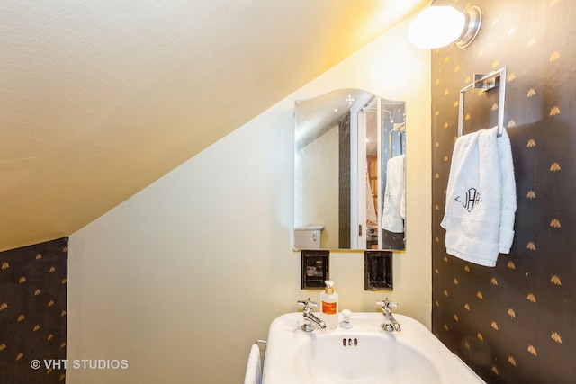bathroom with wallpapered walls