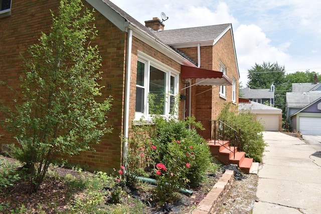33 N Spring Ave, La Grange, IL 60525 - view of home's exterior with brick siding, a garage, a chimney, and an outbuilding