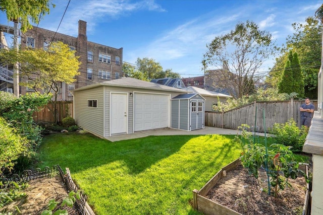 1331 W Granville Ave, Chicago, IL 60660 - view of yard featuring a storage unit, a garage, a vegetable garden, a fenced backyard, and an outbuilding