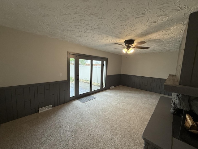 405 9th St, Mazon, IL 60444 - unfurnished living room with a wainscoted wall, ceiling fan, a textured ceiling, and visible vents