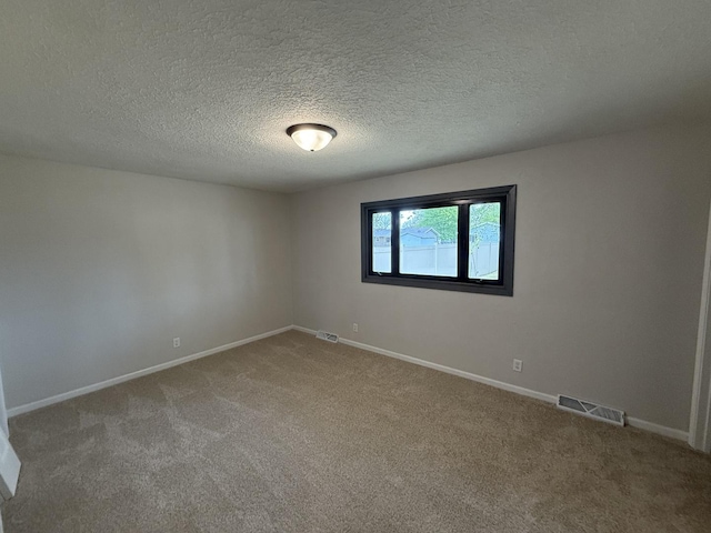405 9th St, Mazon, IL 60444 - spare room featuring a textured ceiling, baseboards, visible vents, and carpet