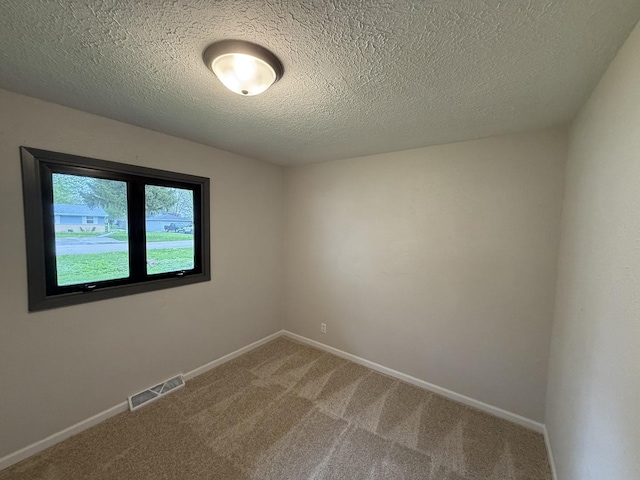 405 9th St, Mazon, IL 60444 - spare room with baseboards, carpet, a textured ceiling, and visible vents