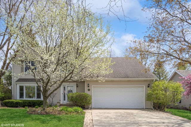view of front of property with concrete driveway, a front lawn, roof with shingles, and a garage
