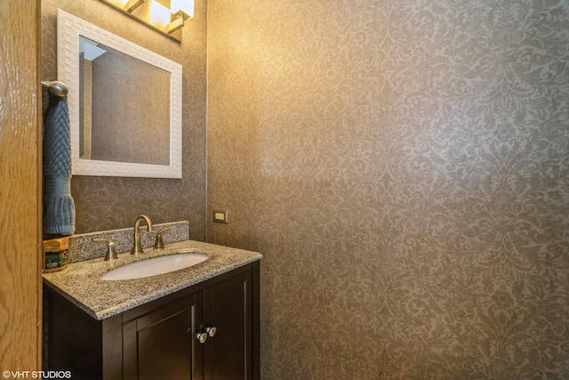 bathroom featuring vanity and wallpapered walls