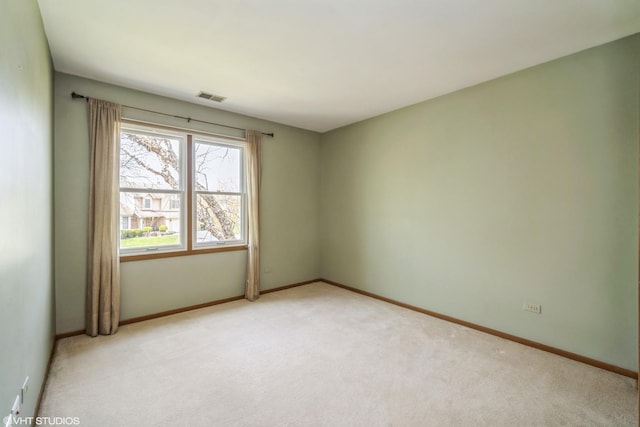 unfurnished room featuring visible vents, baseboards, and light carpet