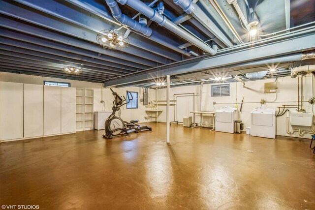 below grade area featuring a sink, separate washer and dryer, electric panel, and visible vents