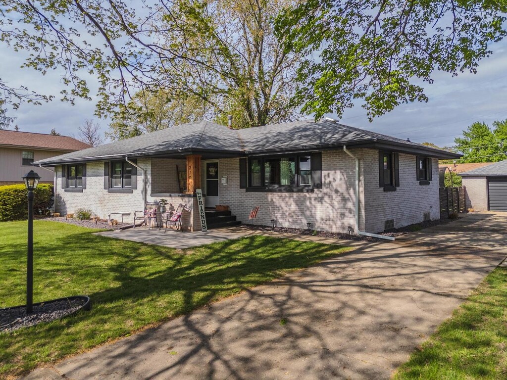 218 Ivanhoe Way, Bloomington, IL 61701 - view of front facade featuring a front yard, brick siding, crawl space, an outbuilding, and a detached garage