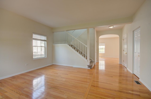 1120 Redwood Ln, Minooka, IL 60447 - empty room featuring visible vents, arched walkways, plenty of natural light, and stairway