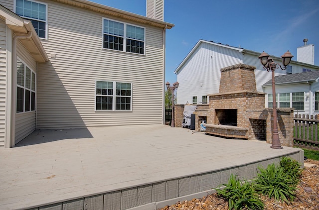 1120 Redwood Ln, Minooka, IL 60447 - rear view of house featuring a wooden deck, fence, a chimney, and an outdoor brick fireplace