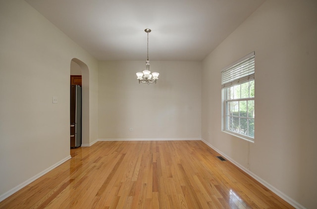1120 Redwood Ln, Minooka, IL 60447 - spare room with an inviting chandelier, visible vents, arched walkways, baseboards, and light wood-style floors
