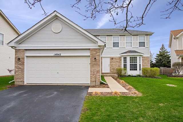 traditional home featuring an attached garage, aphalt driveway, a front lawn, and brick siding