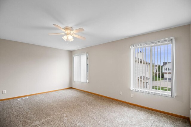 unfurnished room with baseboards, a ceiling fan, and a healthy amount of sunlight