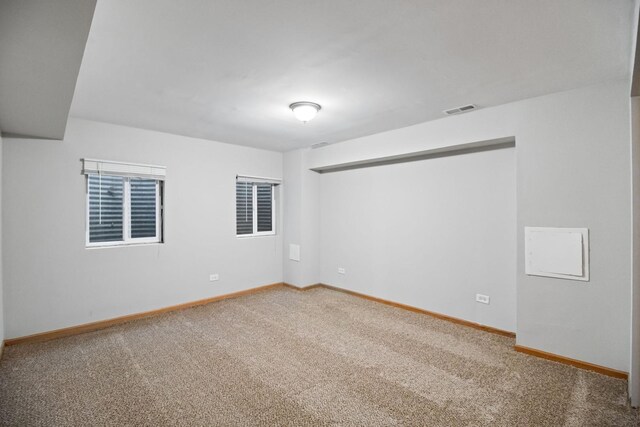 carpeted empty room featuring visible vents and baseboards