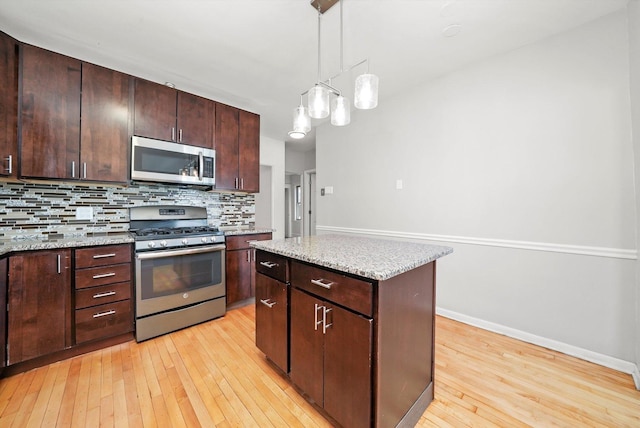 2910 N 76th Ct, Elmwood Park, IL 60707 - kitchen with appliances with stainless steel finishes, light wood-style flooring, tasteful backsplash, baseboards, and pendant lighting